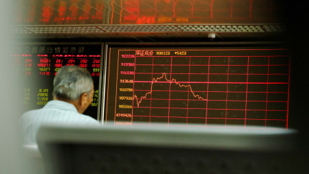 A man sits in front of a board showing market information at a securities brokerage house in Beijing, China August 5, 2019. REUTERS/Thomas Peter