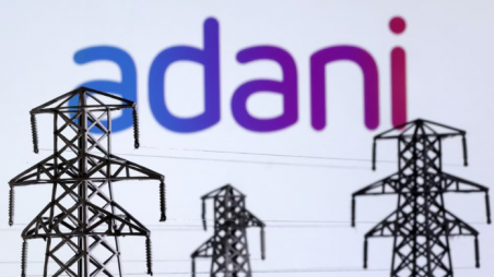 This illustration shows miniatures of power poles and the Adani Green Energy logo taken on December 9, 2022. Photo: Reuters