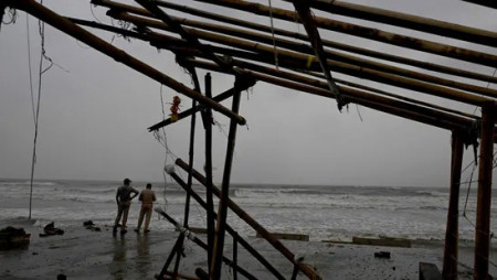 Police personnel stand guard at the shore near a damaged shop on a beach in Balasore on October 24, hours before Cyclone Dana hit the coasts of Odisha and West Bengal. Photo: AFP