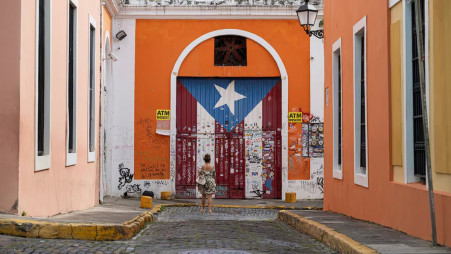 A woman takes photos of a door with a Puerto Rican flag painted on it, Old San Juan, Puerto Rico, October 28, 2024. Photo: REUTERS/Ricardo Ardueng