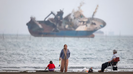 People gather on a beach, as a vessel in the Strait of Hormuz is visible, near the beach of Bandar Abbas, Iran, May 31, 2026. Photo: Amirhosein Khorgooi/ISNA/WANA (West Asia News Agency) via REUTERS