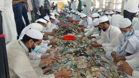 People count money found in the donation boxes of the Pagla Mosque in Kishoreganj today, 27 June 2026. Photo: TBS