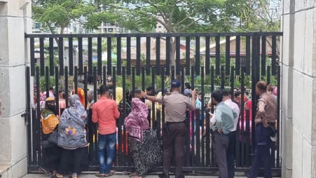 Workers of Shangu Tex Ltd gather outside the locked gates of the BGMEA office in Uttara, demanding payment of their outstanding dues. Photo: TBS
