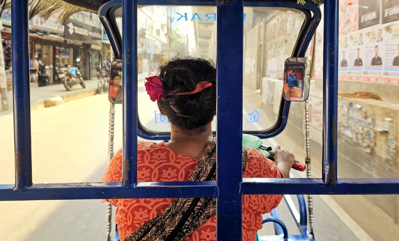 Khaleda, a female battery-run rickshaw driver, spends long hours on Dhaka's roads to earn a living despite increasingly harsh temperatures. Photo: Tashahud Ahamed Rafim/TBS