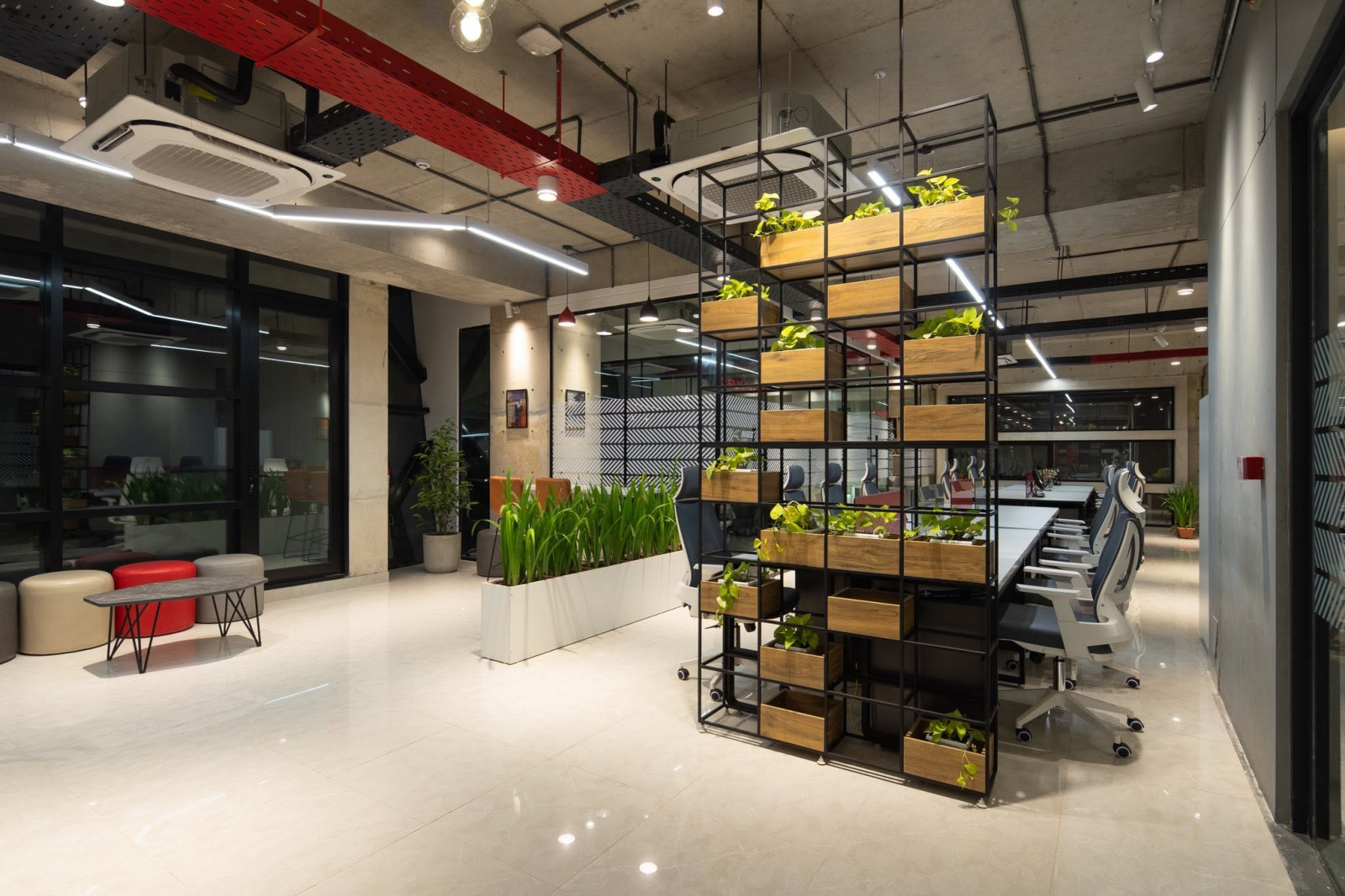 Open shelving in a contemporary workspace introduces greenery and visual separation while maintaining an open, collaborative environment. Photo: Srishty architecture and consultancy