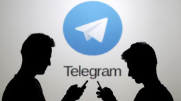 Two men pose with smartphones in front of a screen showing the Telegram logo in this picture illustration taken in Zenica, Bosnia and Herzegovina November 18, 2015. Photo: REUTERS/Dado Ruvic/File Photo