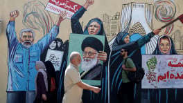 People walk on a street near a mural featuring an image of the late Supreme Leader of Iran, Ayatollah Ali Khamenei, in Tehran, Iran June 8, 2026. Photo: Majid Asgaripour/WANA (West Asia News Agency) via Reuters 