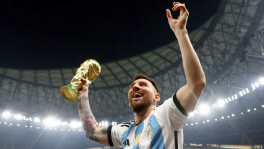 Argentina's Lionel Messi celebrates winning the World Cup with the trophy. Photo: Reuters