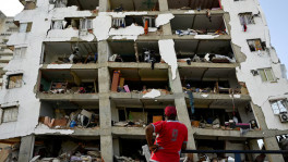 A man looks at a damaged building in the aftermath of earthquakes in La Guaira, Venezuela, 25 June, 2026. REUTERS/Maxwell Briceno