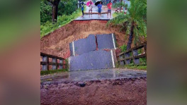 Locals inspect the collapsed section of a bridge on the Rangamati-Bandarban road in Rangunia, Chattogram, after heavy rain and hill runoff damaged the approach in the early hours of today. Photo: TBS