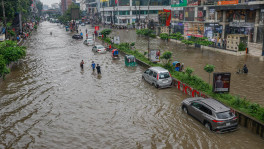 People wade through knee-deep water while vehicles struggle along a flooded road in Dhanmondi 27 of the capital after heavy rain triggered severe waterlogging across parts of the capital. Photo: TBS/Rajib Dhar
