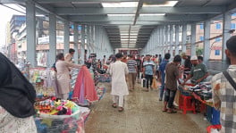 Hawkers occupy much of the walking space on Dhaka South's escalator-equipped footbridge at New Market, forcing pedestrians through a narrow passage. Built at a cost of Tk9.77 crore and inaugurated in February, the city's only escalator-equipped footbridge has become a trading spot for vendors evicted from nearby footpaths. Photo: Mahadi Hasan/TBS