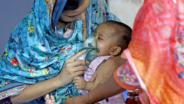 A woman nebulises a child undergoing treatment for measles at a hospital. Photo: TBS 